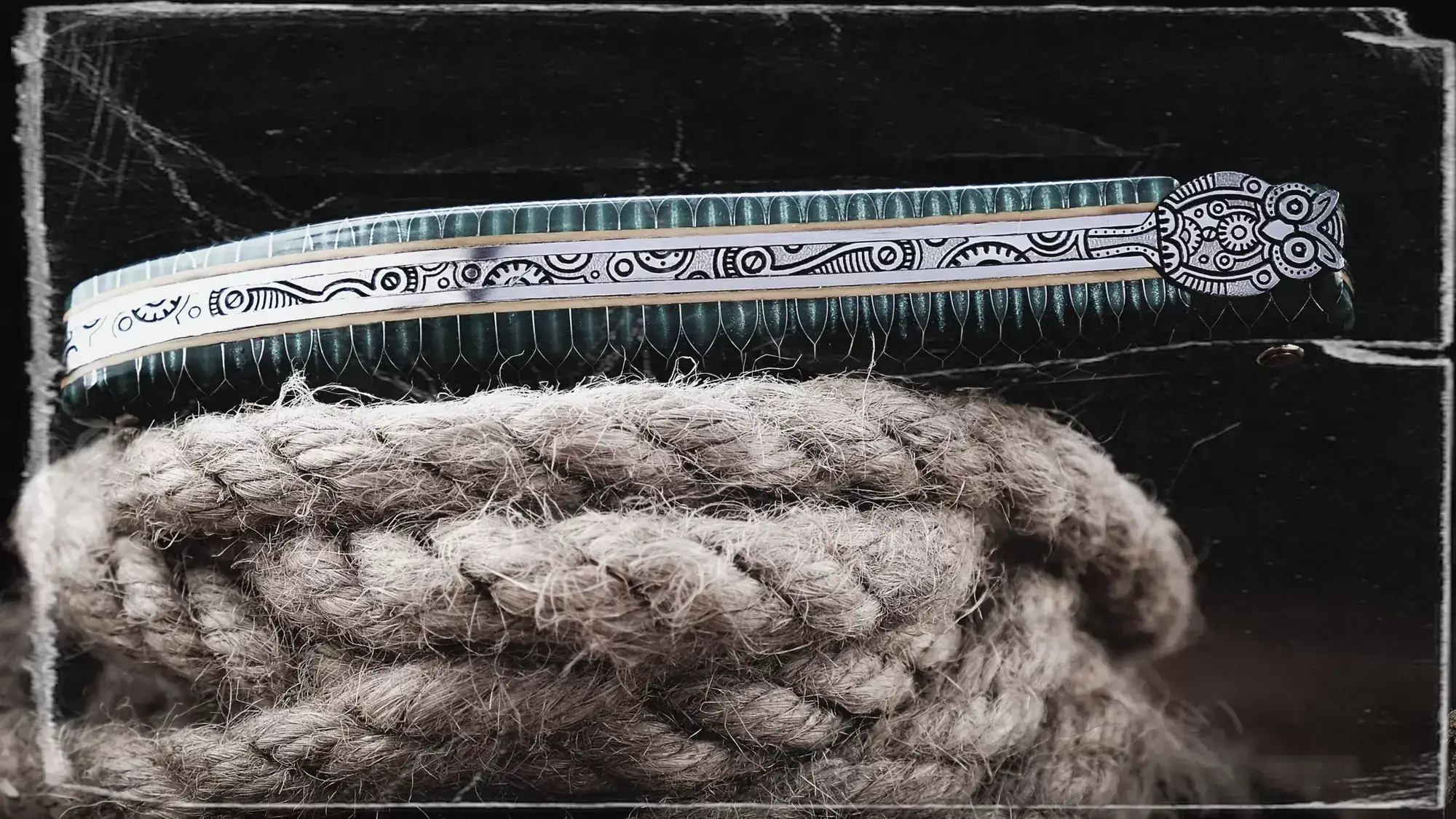 Laguiole-Taschenmesser mit graviertem Rücken auf einem Tau, Schwarzweißaufnahme