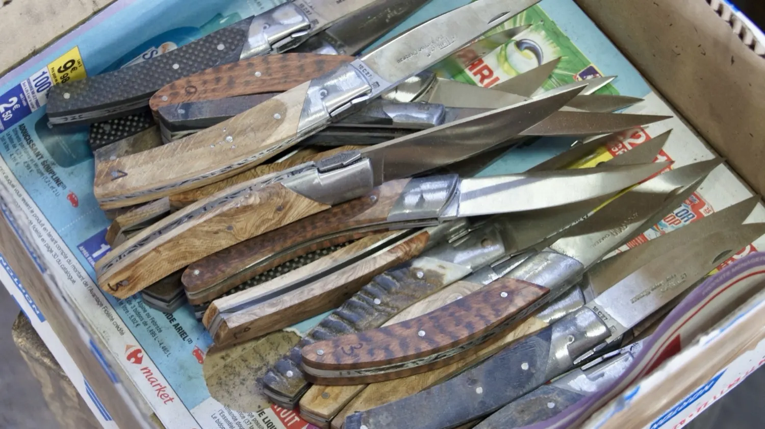 Fertige Messer in der Kiste, jedes mit einem anderen Griffholz. Bis hierher hat jedes davon dieselben Arbeitsgänge durchlaufen.